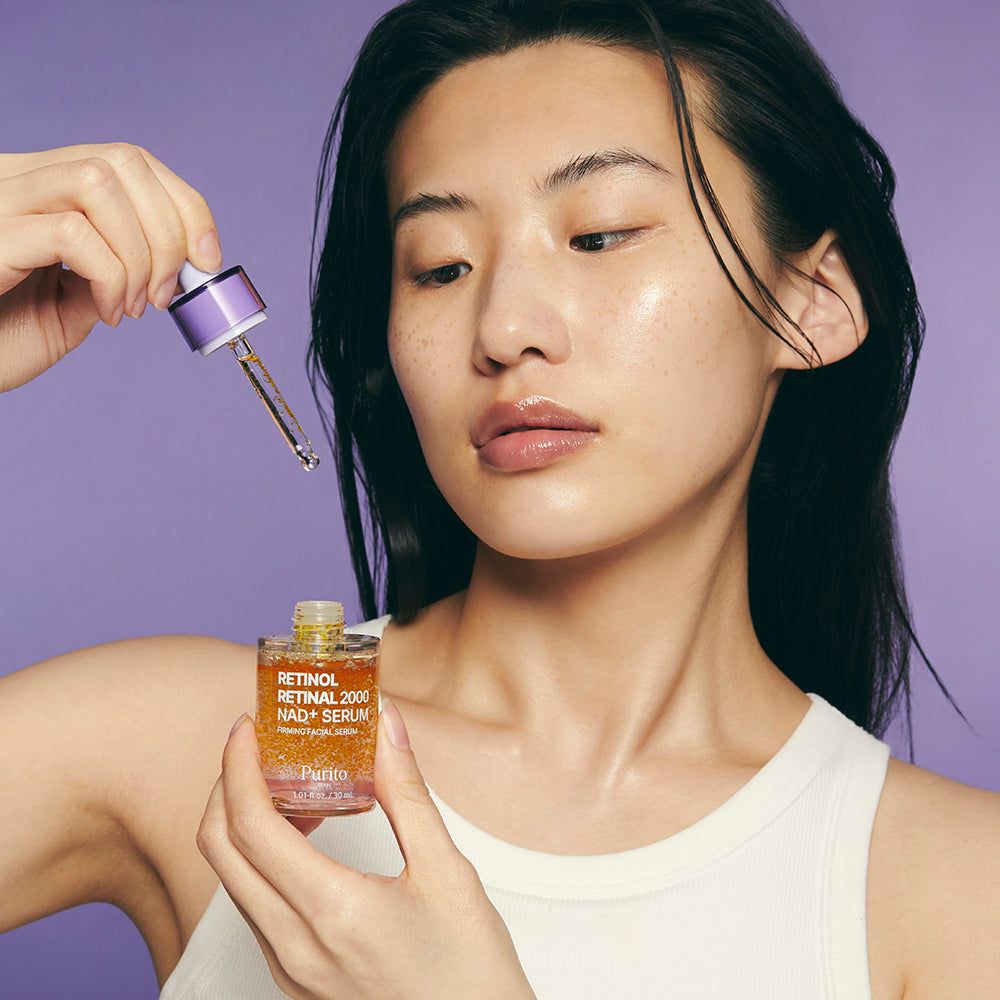 Donna con siero Purito Retinol Retinal 2000 NAD+ e contagocce.